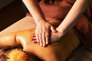 女性クライアントの背面をアロマオイルでマッサージしている画像 背中をアロマオイルマッサージ